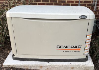 Generac Guardian Series 22 kW generator placed on a concrete slab next to a brick wall.